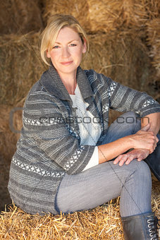 Middle Aged Blond Woman Sitting on Hay Bale