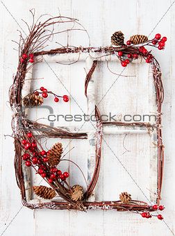 Wooden frame window with red berries, hawthorn, snow and cones Christmas Happy New Year background