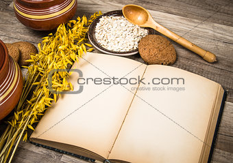 Oatmeal cookies and an old recipe book on the kitchen table 