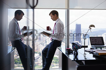 Business Person Drinks Coffe And Reads News On Tablet