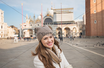 Portrait of happy young woman standing on Piazza San Marco