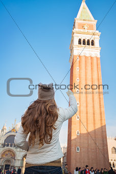 Seen from behind woman pointing on tower of St Mark's Basilica