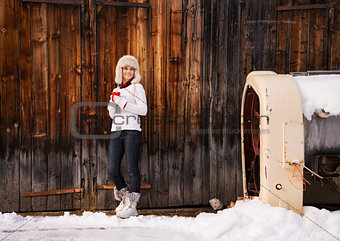 Happy woman with red cup in front of rustic wood wall