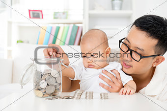 Father and baby saving money