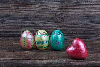 Easter eggs with red heart on wooden backgorund