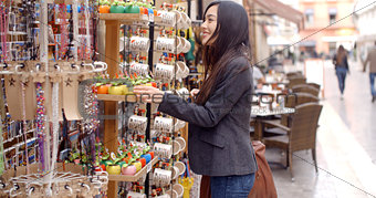 Smiling young woman checking out shop merchandise
