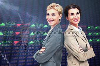 Composite image of serious businesswomen standing back on back