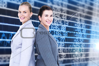 Composite image of attractive businesswomen standing back-to-back