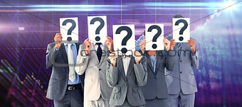 Composite image of business colleagues hiding their face with question mark sign