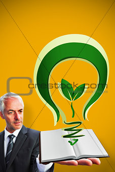 Composite image of businessman showing a book