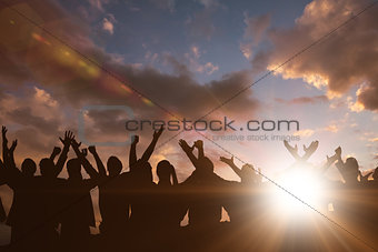 Composite image of silhouetters celebrating