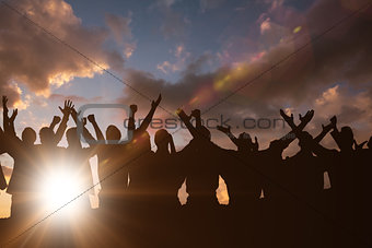 Composite image of silhouetters celebrating