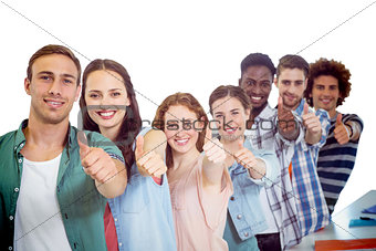 Composite image of fashion students showing thumbs up