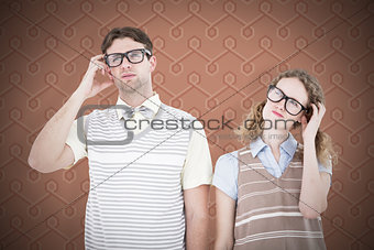 Composite image of geeky hipster couple thinking with hand on temple