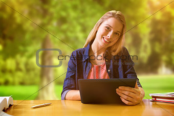 Composite image of student studying in the library with tablet