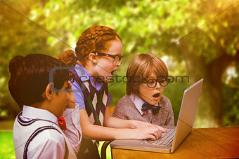 Composite image of pupils using laptop