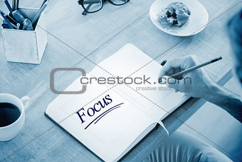 Focus against man writing notes on diary
