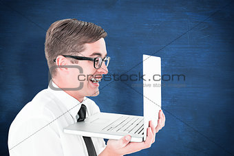 Composite image of geeky businessman holding his laptop