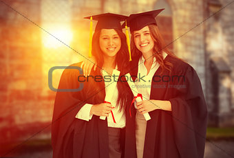 Composite image of two women embracing each other after they graduated from university