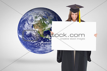 Composite image of a smiling woman as she holds and looks at a blank sheet in front of her