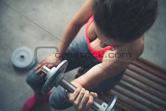 Closeup on woman lifting dumbbell