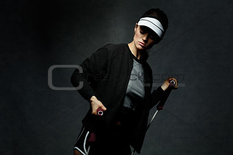 Fit woman workout with resistance band against dark background