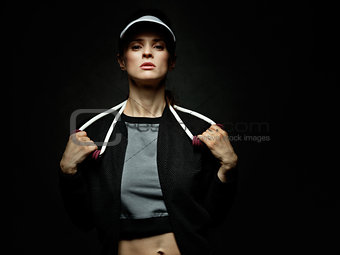 Woman athlete holding resistance band against black background