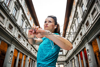 Fitness young woman stretching next to Uffizi gallery, Florence