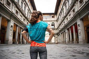 Sporty female staying in front of Uffizi gallery, Florence