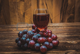 glass of wine or grape juice and fruit on wooden table