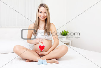 Pregnant woman relaxing on the bed