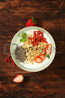 healthy breakfast of muesli, yoghurt, chia seeds, fruit and goji