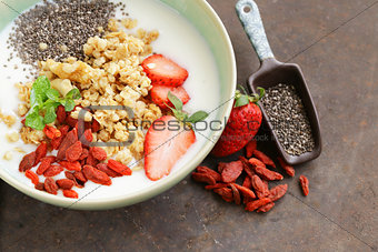 healthy breakfast of muesli, yoghurt, chia seeds, fruit and goji