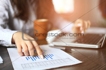 Hands of financial manager taking notes when working on report