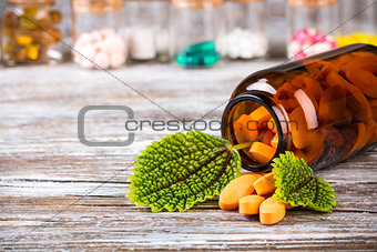 Alternative medicine in glass containers with green leaves 