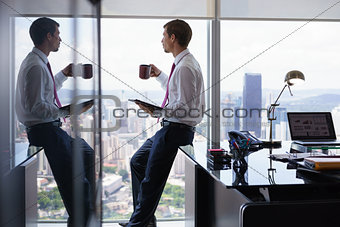 Business Man Drinking Coffe And Reading News On Tablet
