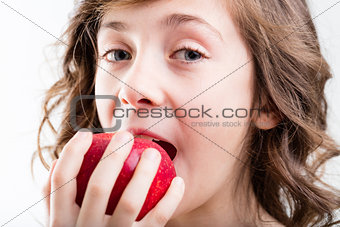 girl eats red apple on white background