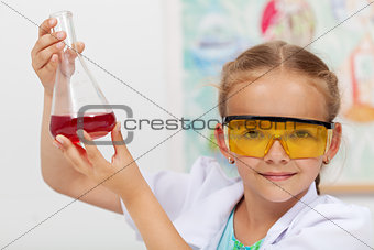 Young girl checking the result of chemical experiment