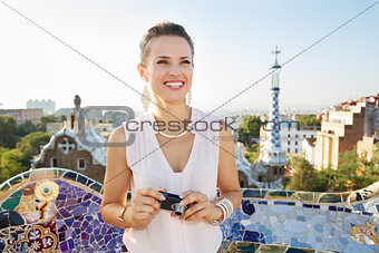Woman tourist with photo camera in Park Guell, Barcelona, Spain