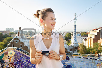 Woman tourist with photo camera looking aside in Park Guell