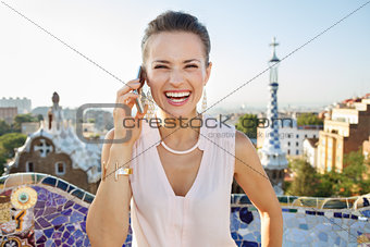 Smiling woman talking smartphone while in Park Guell, Barcelona