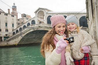 Mother showing photo to daughter in front of Rialto Bridge
