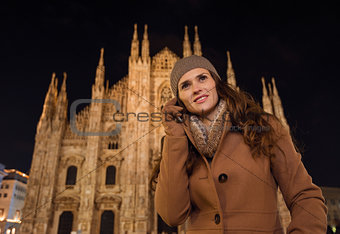Young woman talking cell phone near Duomo in evening, Milan