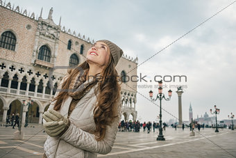 Happy woman sightseeing on St. Mark's Square near Dogi Palace