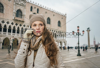 Woman tourist talking mobile phone on St. Mark's Square, Venice