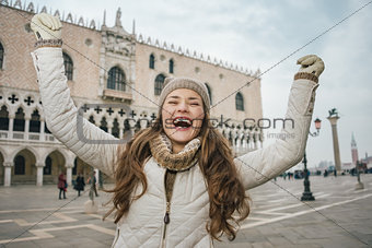 Happy young woman tourist rejoicing on St. Mark's Square, Venice