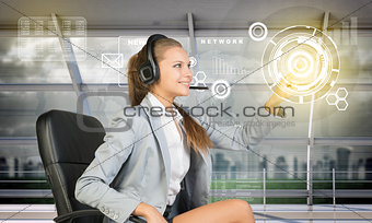 Smiling businesslady touching holographic screen