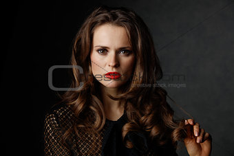 Portrait of woman with long wavy brown hair and red lips