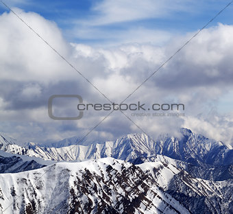 Winter snowy mountains and cloudy sky