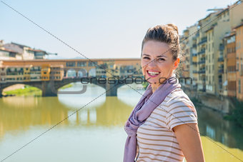 Smiling tourist standing on the bridge overlooking Ponte Vecchio